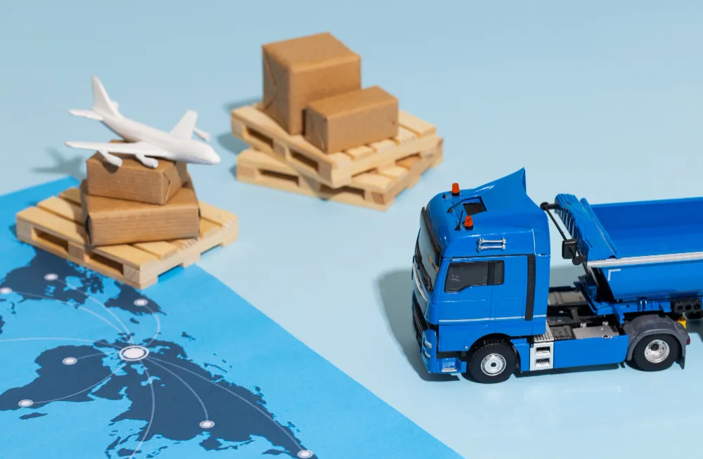Miniature truck and pallet goods on world map backdrop.