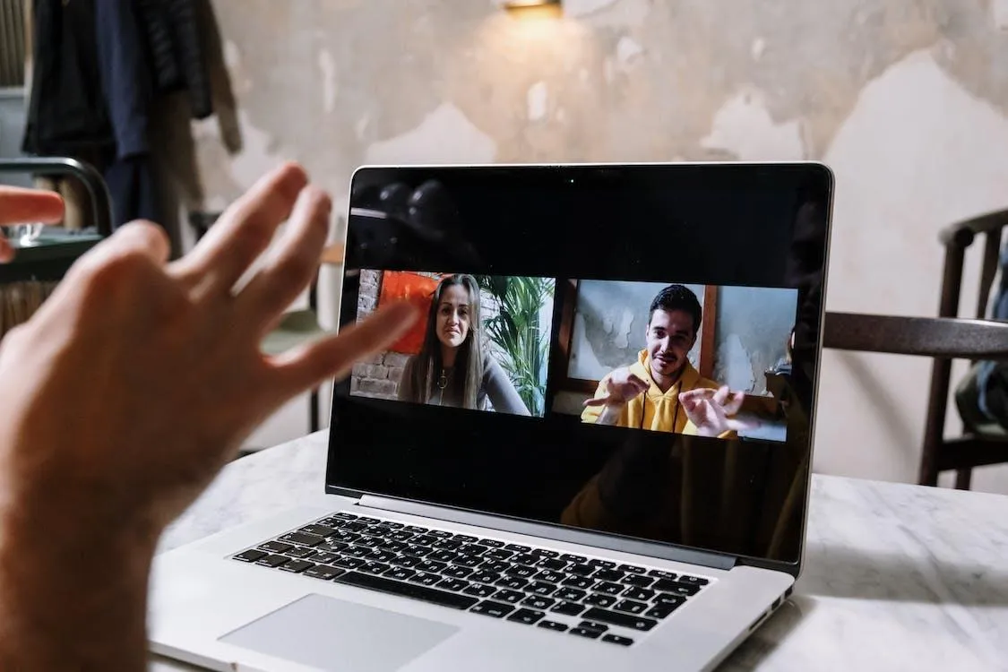 man and woman video call on laptop