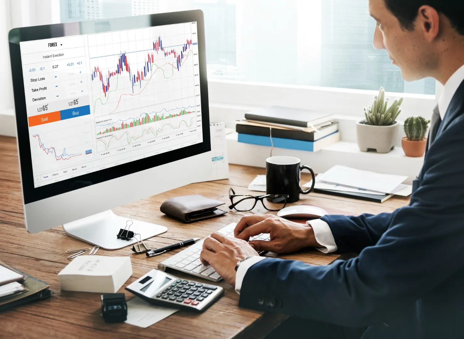 Businessman analyzing forex charts on a desktop computer, showing various financial graphs and data.