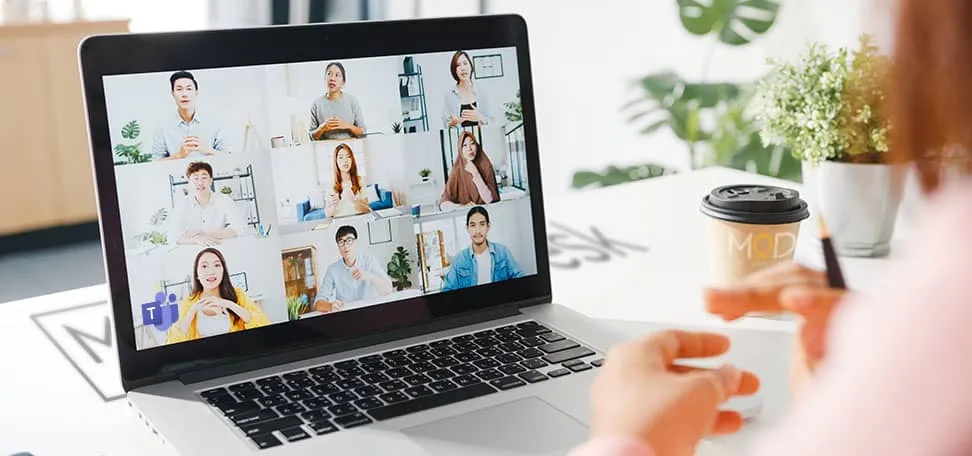 Person attending an online team meeting via video call on a laptop.