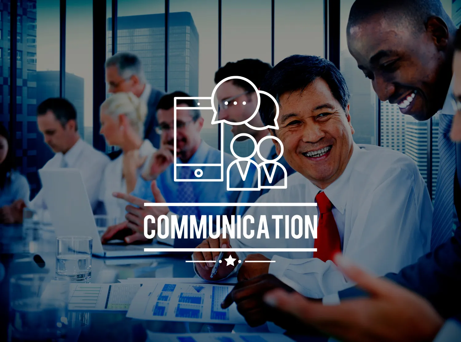 Smiling business professionals in a meeting, discussing communication strategies with graphs and charts on the table in a corporate office.