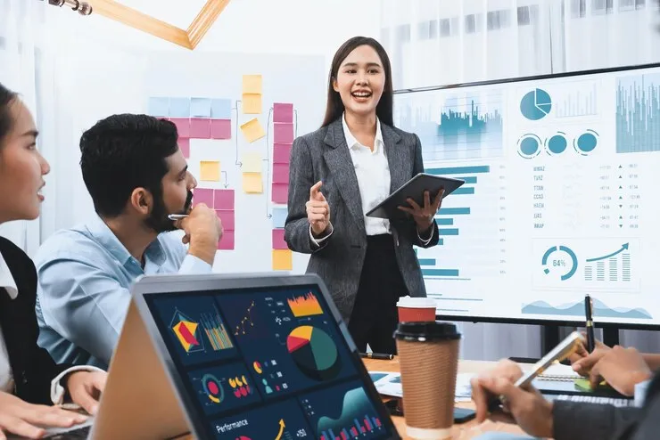 Businesswoman presenting data analysis to a team with charts