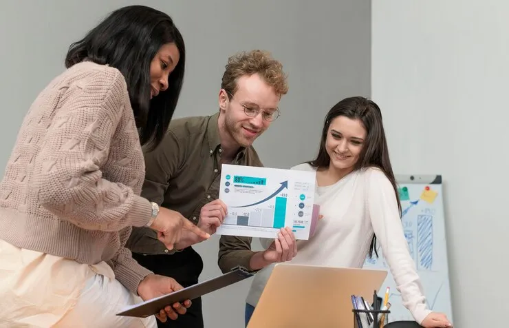 Team discussing a business report in front of a laptop.
