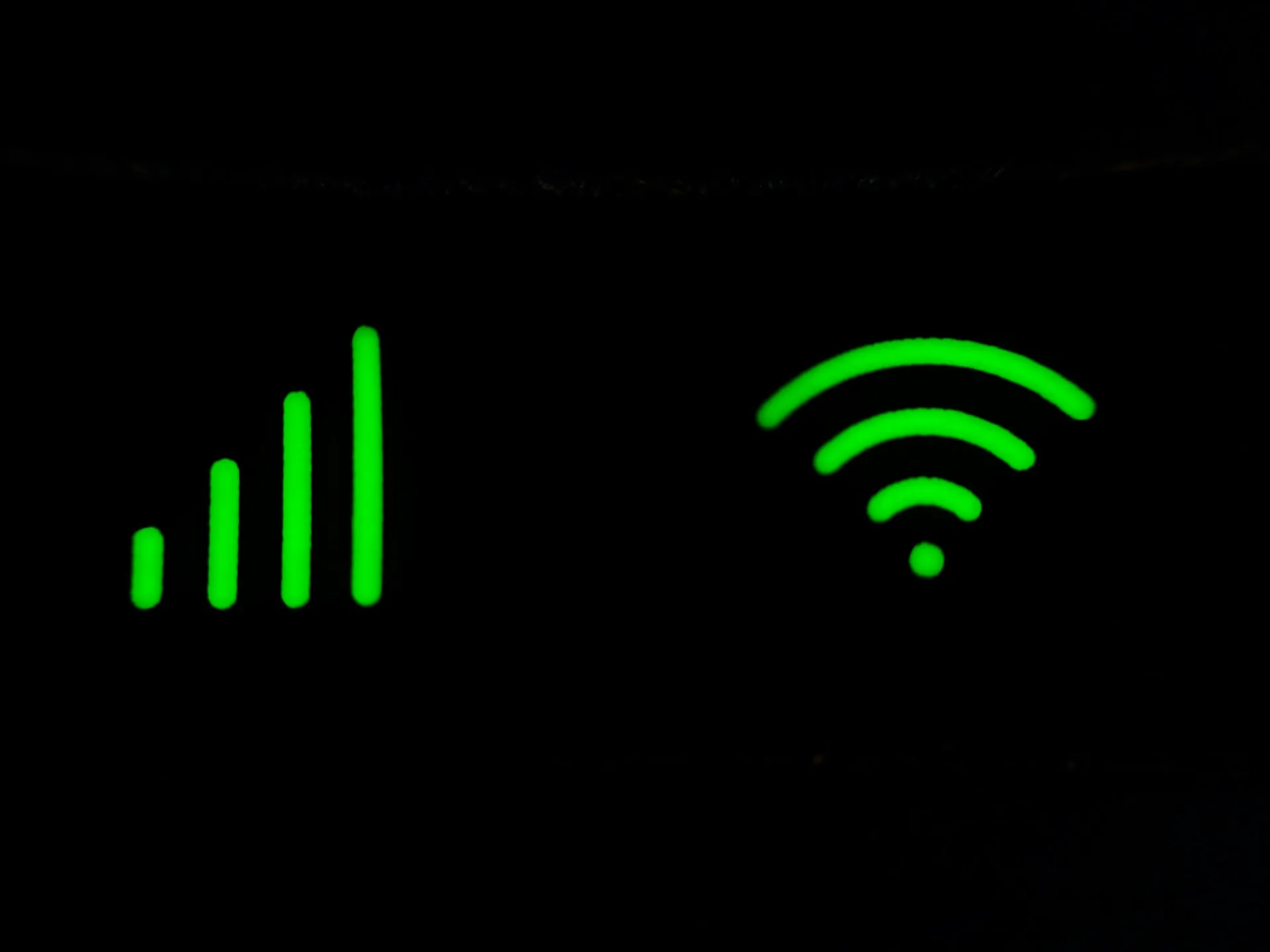 Green signal and WiFi icons illuminated on a black background