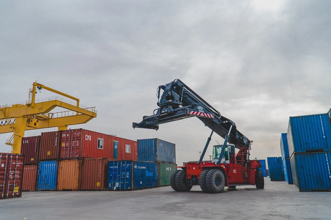 Crane moving shipping containers in a warehouse or port.