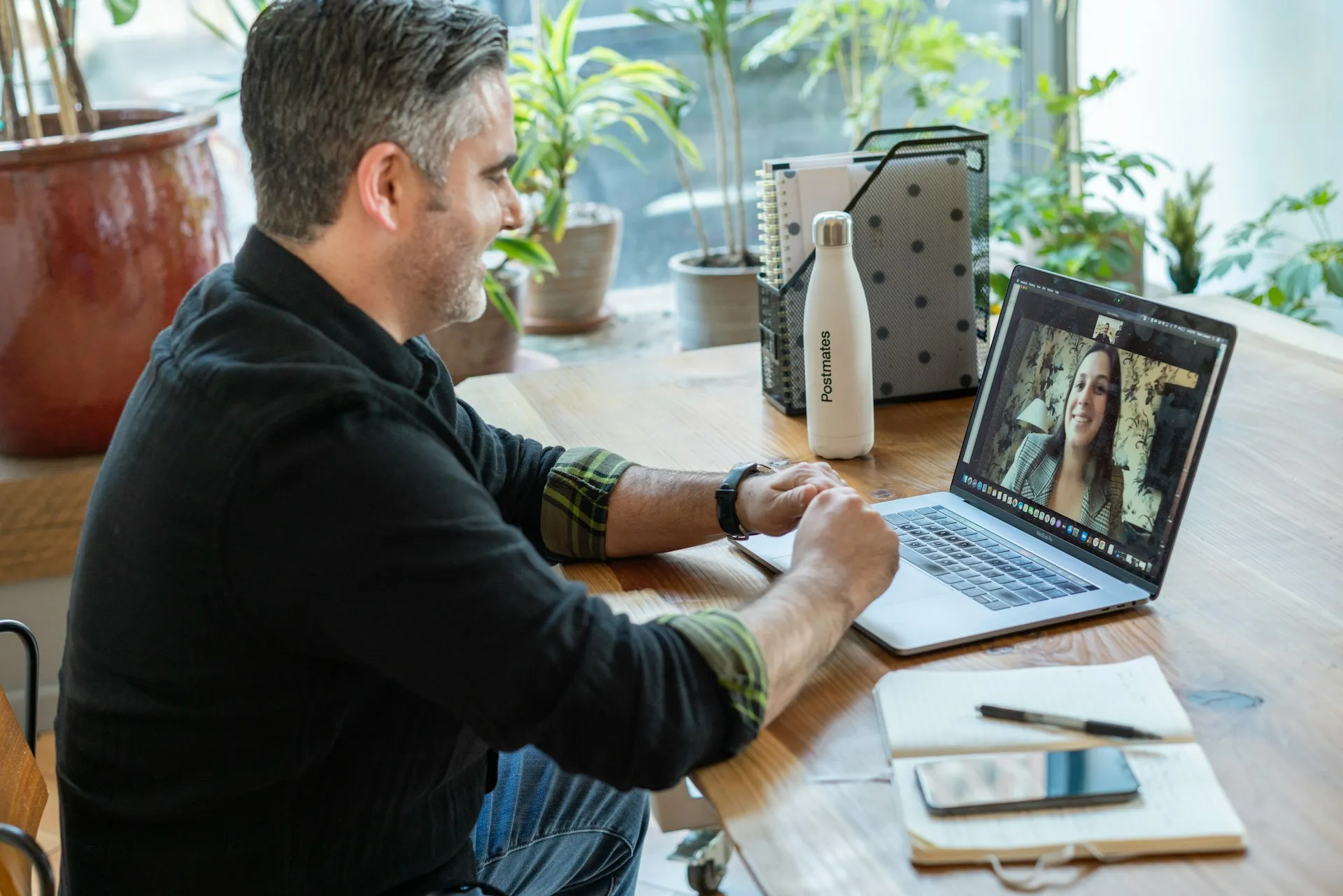 Professional man on video call at organized home office desk.