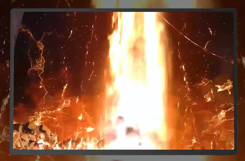 Dramatic blazing fire with orange flames shooting upward, sparks flying.