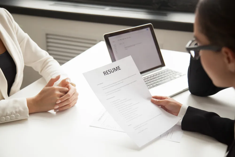 Business executives reviewing resume during formal job interview discussion.